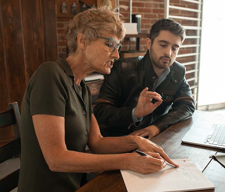 Kobieta z mężczyzną siedzący przy biurku podczas kursu indywidualnego w szkole językowej oława.